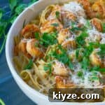 Cajun Shrimp Pasta with Roasted Red Pepper Sauce 6 white bowl of roasted red pepper pasta on gray background with parsley