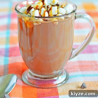 Spiked hot chocolate in a mug, decorated with marshmallows and chocolate syrup and caramel syrup