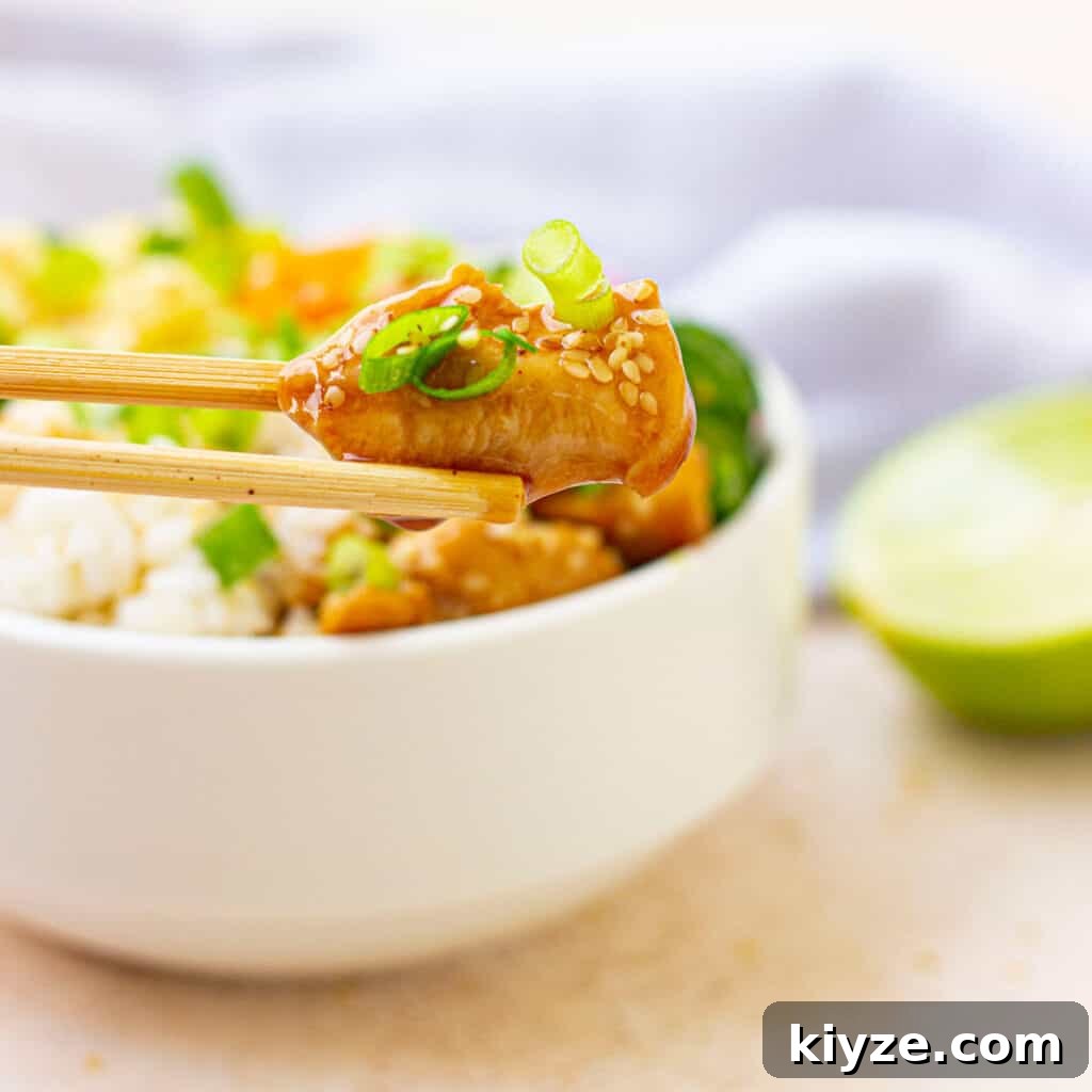 chopstick holding piece of teriyaki chicken