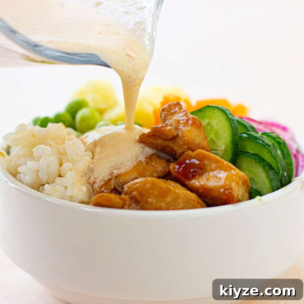 pouring sauce on teriyaki chicken bowl