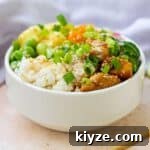 white bowl with rice, vegetables, and teriyaki chicken