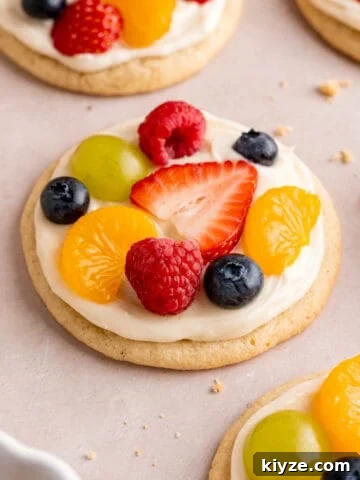 Mini fruit pizza sugar cookies with cream cheese icing and fresh fruit.