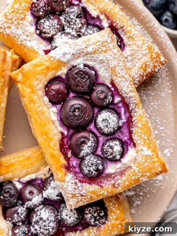Blueberry cheese puff pastries dusted with powdered sugar.