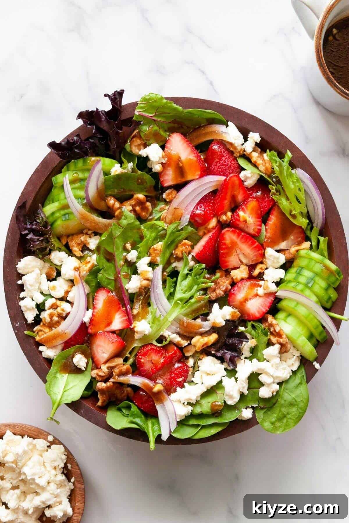 Easy summer strawberry goat cheese salad with balsamic dressing, walnuts, and spinach.