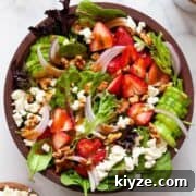 Easy summer strawberry goat cheese salad with balsamic dressing, walnuts, and spinach.
