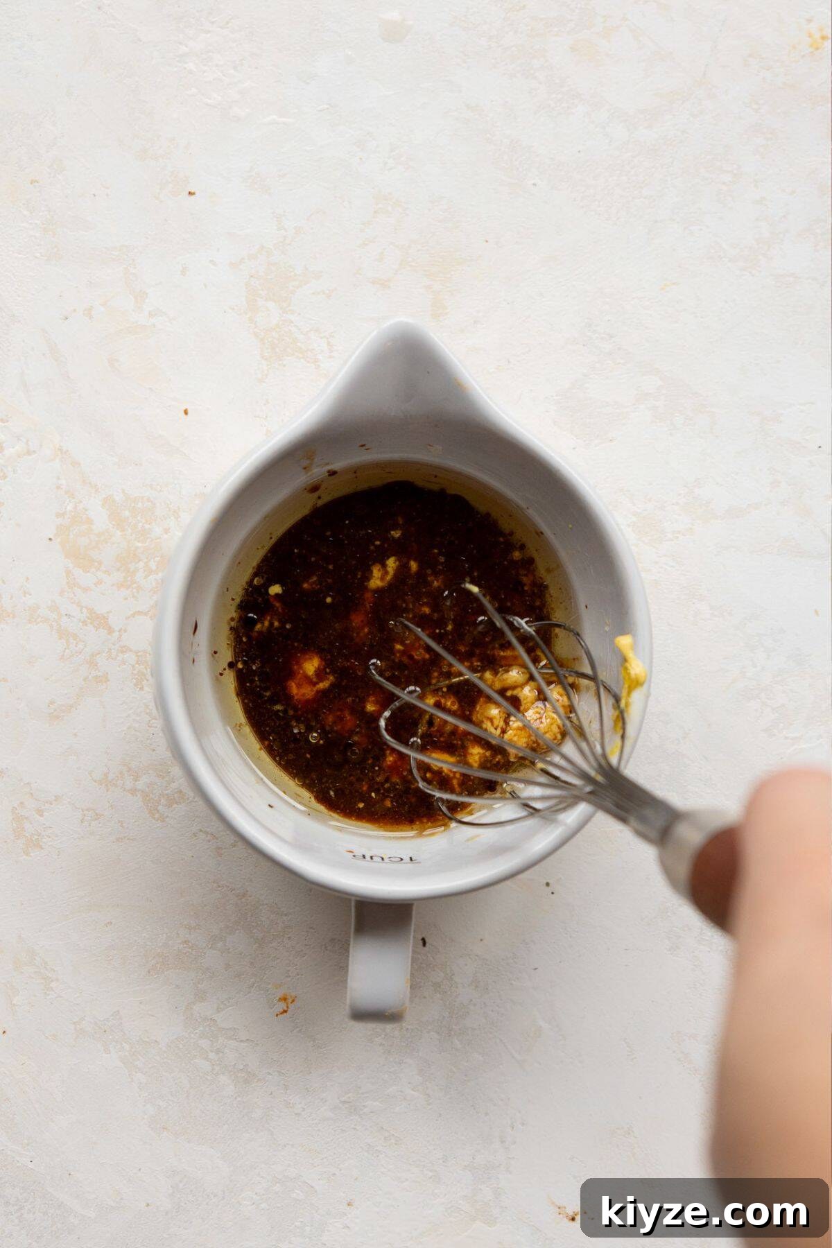 Whisking together the balsamic dijon vinaigrette in a small bowl