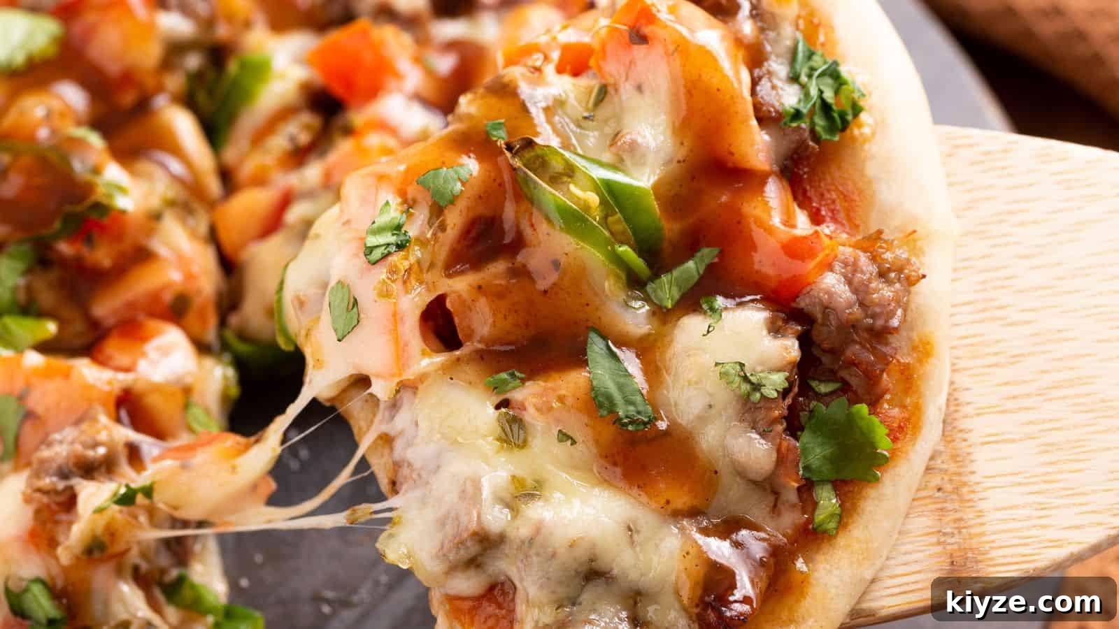 25 Comforting Main Dishes That Make You Forget the Grill 23 Close-up of a cheesy Mexican steak pizza on a wooden spatula.