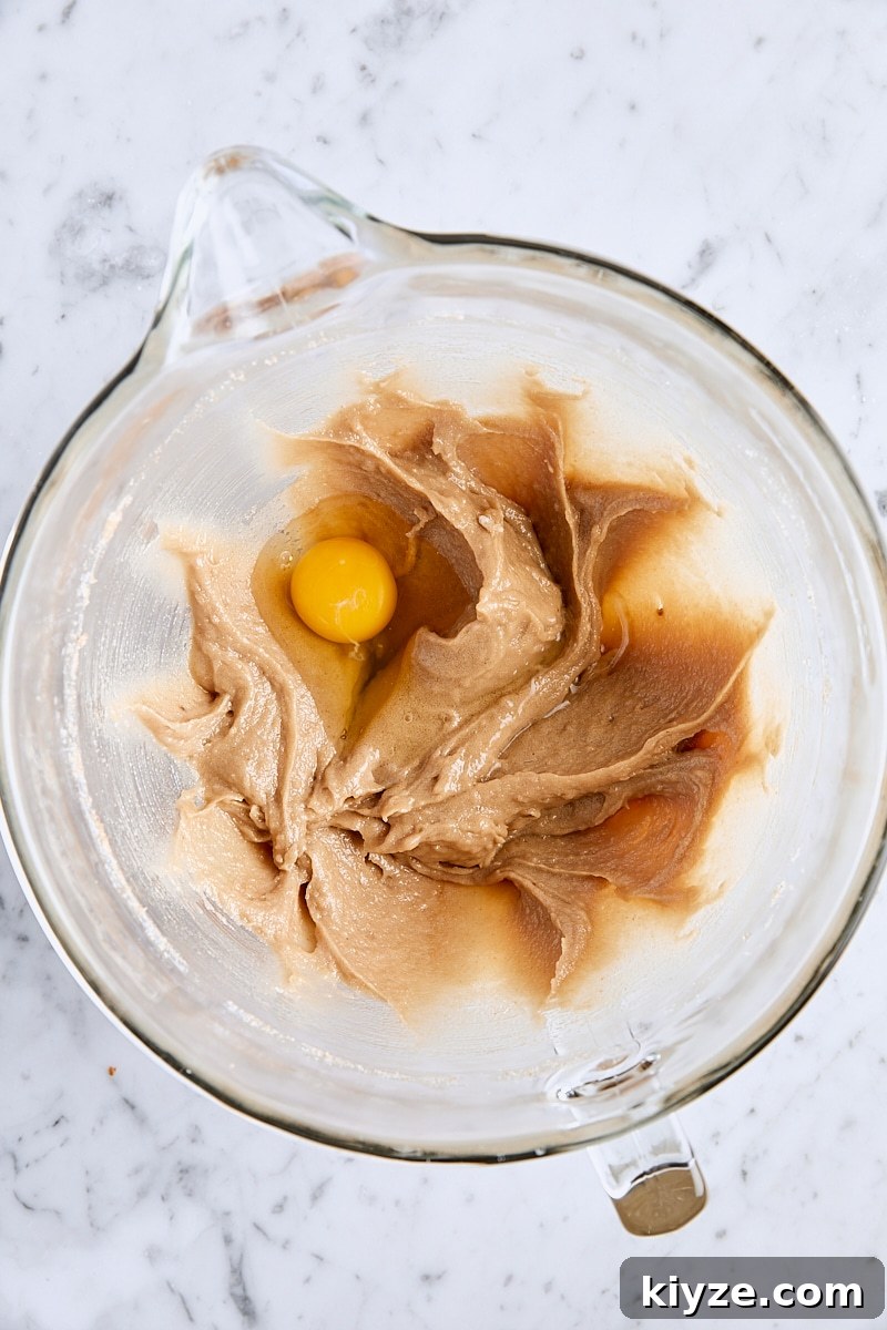 Spiced Bundt Cake with Gooey Butterscotch Topping 9 Egg added to batter in glass mixing bowl