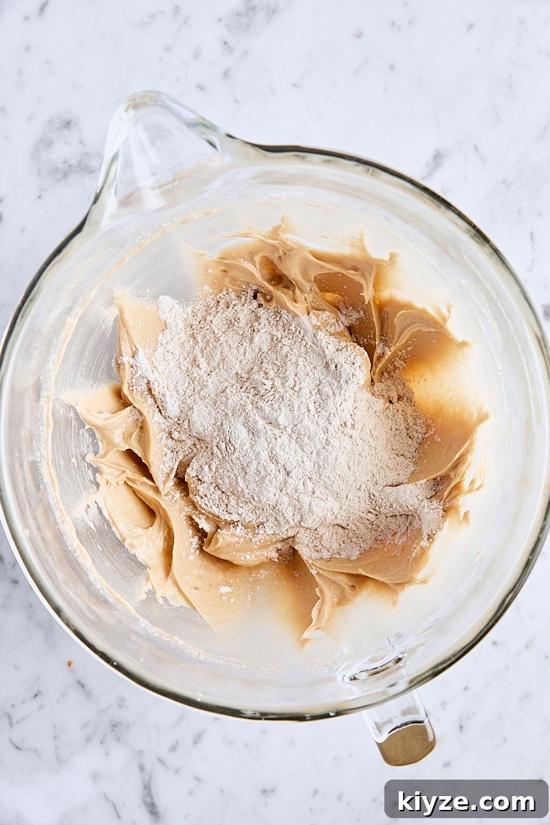 Spiced Bundt Cake with Gooey Butterscotch Topping 10 Dry ingredients added to bundt cake batter in glass mixing bowl