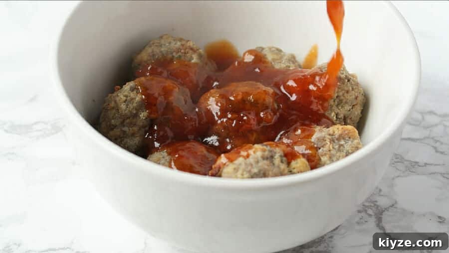 Sweet and Spicy Apricot Glaze for Meatballs and Dipping Sauce 4 sweet & spicy apricot glaze being poured over the best baked meatballs