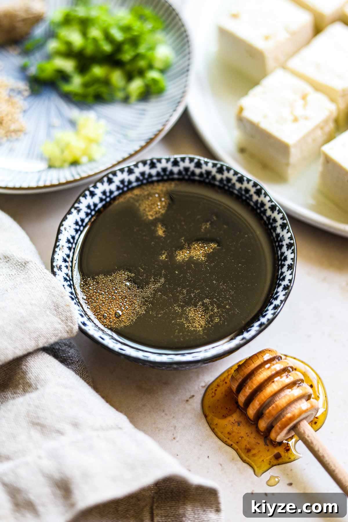 Gluten-Free Honey Teriyaki Sauce Recipe for Every Meal 2 Healthy honey gluten-free teriyaki sauce in a small bowl with a honey dipper.