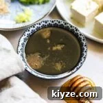 Healthy honey gluten-free teriyaki sauce in a small bowl with a honey dipper.