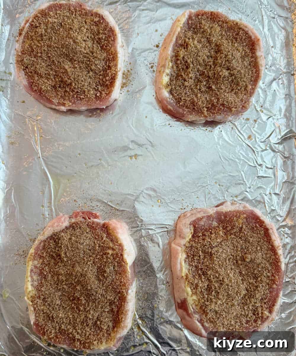 Brown Sugar Baked Pork Chops with Caramelized Glaze 6 seasoned chops on baking sheet.