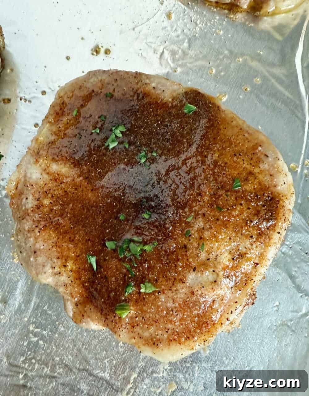 Brown Sugar Baked Pork Chops with Caramelized Glaze 7 baked pork chop with brown sugar and parsley.