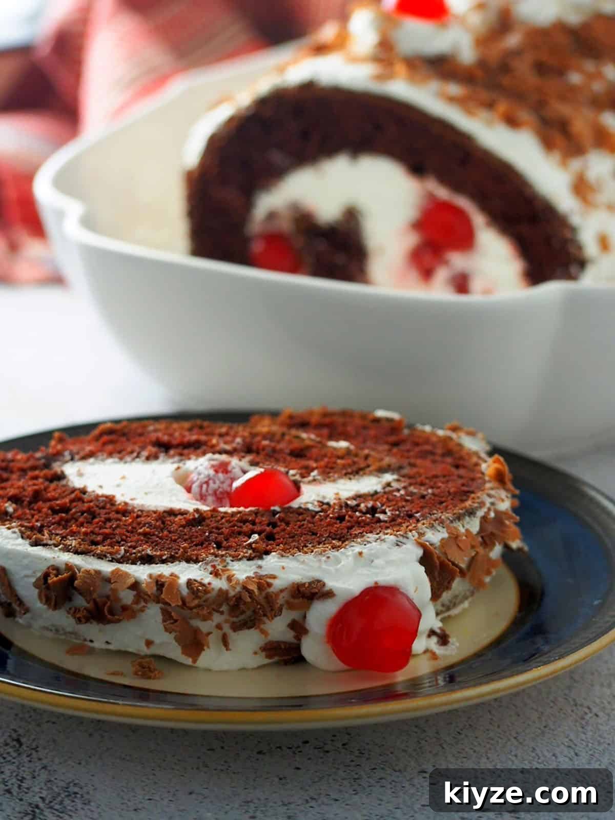 Black Forest Roll Cake Recipe – Chocolate Cherry Swiss Roll 8 slice of black forest swiss roll cake on a serving plate.
