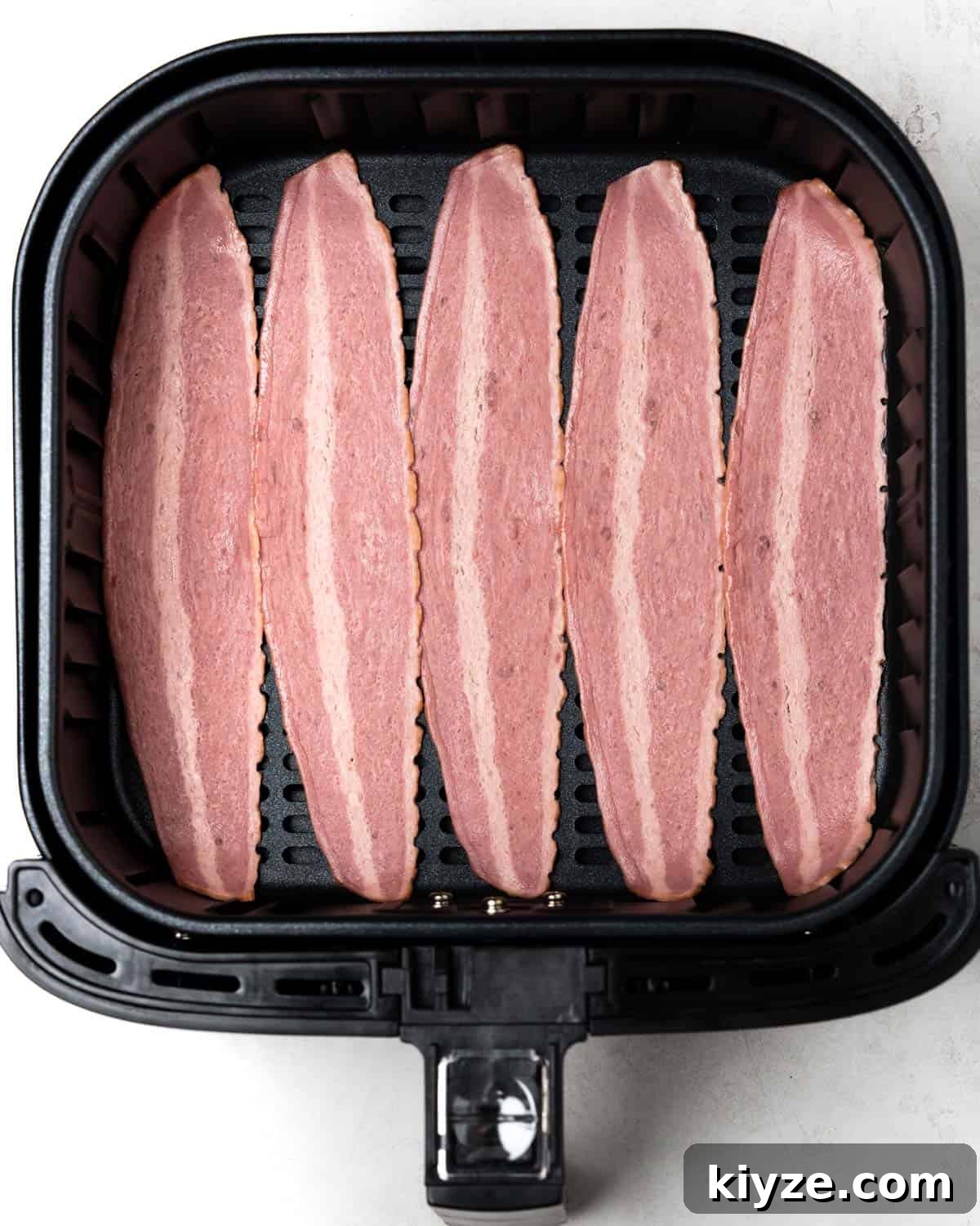Crispy Air Fryer Turkey Bacon Recipe in 15 Minutes 3 single layer of uncooked turkey bacon in the air fryer