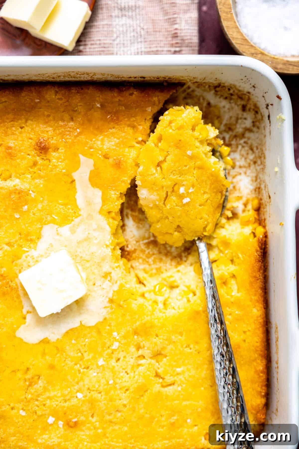 Cheesy Cornbread Casserole with Sausage and Sweet Corn 6 Spoon dishing up cornbread casserole.