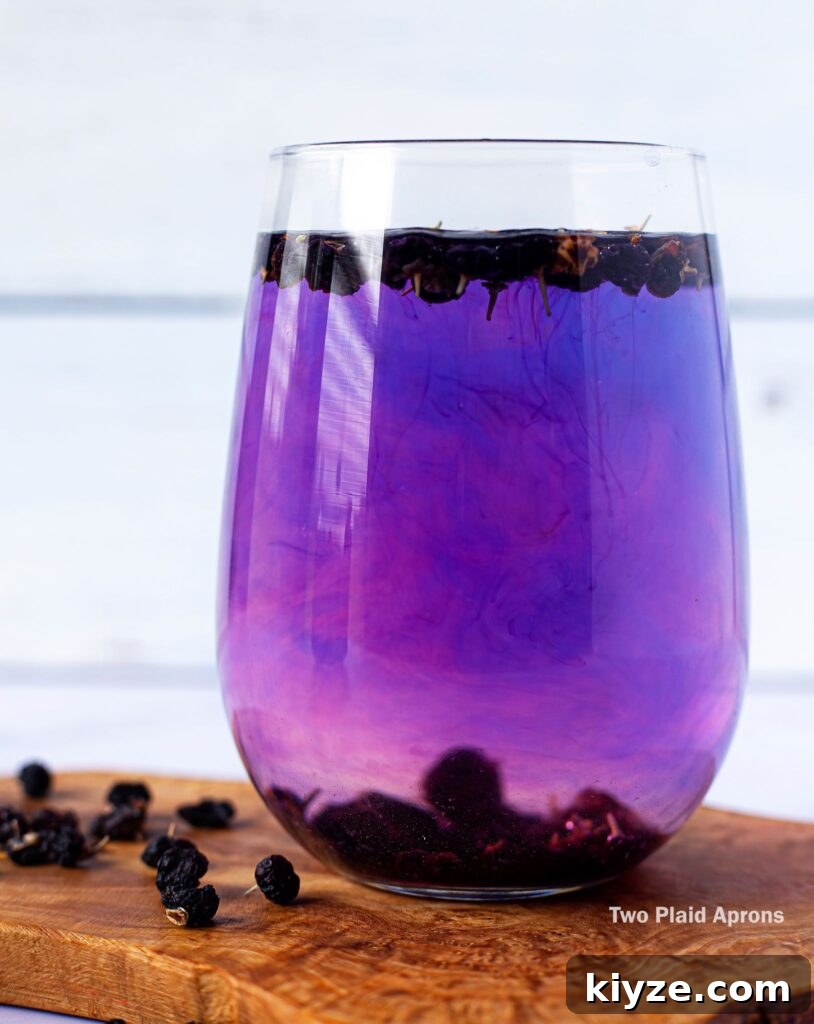 Pink Lemonade with Black Wolfberries: Refreshing Homemade Recipe 10 A glass of black wolfberry tea in the process of turning form violet to pinkish purple.