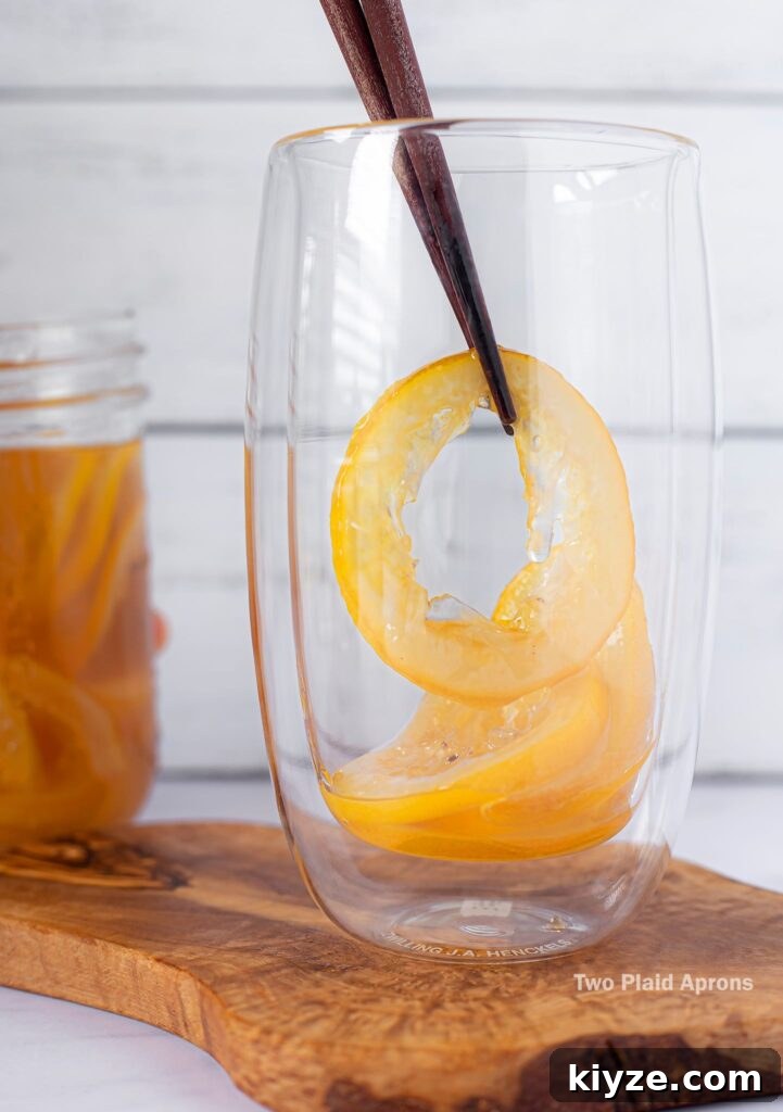 Pink Lemonade with Black Wolfberries: Refreshing Homemade Recipe 12 Placing candied lemon into a glass cup.