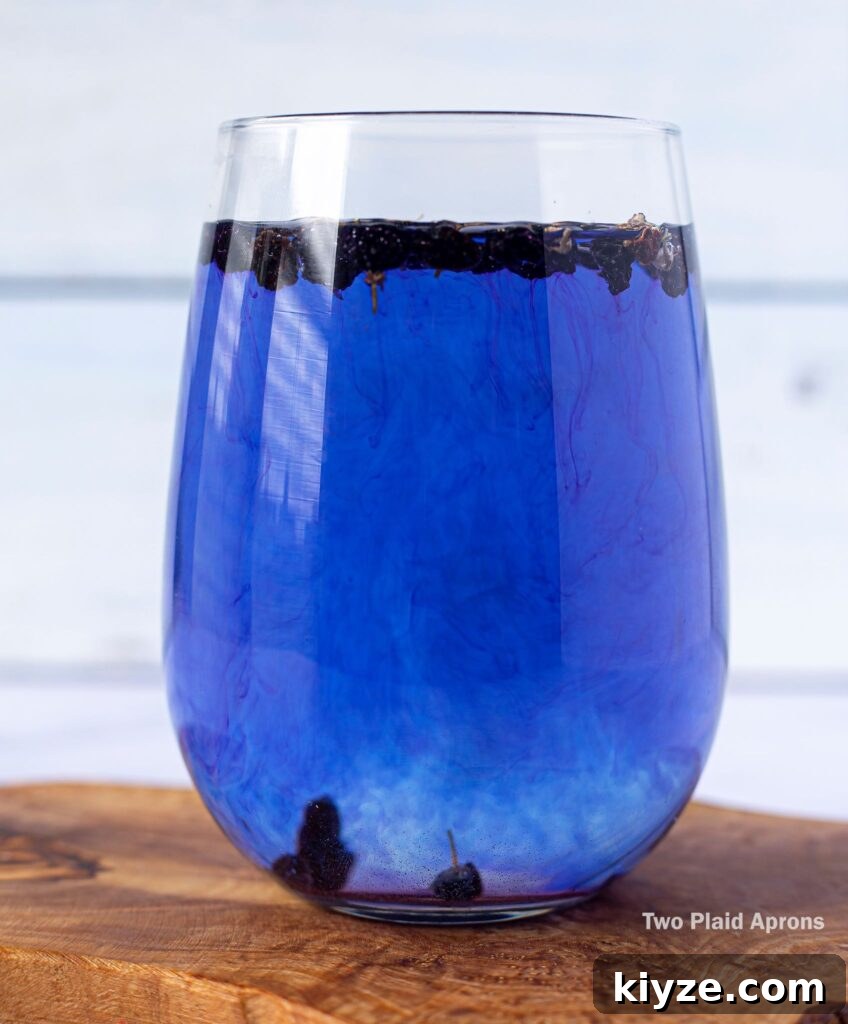 Pink Lemonade with Black Wolfberries: Refreshing Homemade Recipe 6 A glass of black wolfberry tea turning completely royal blue.