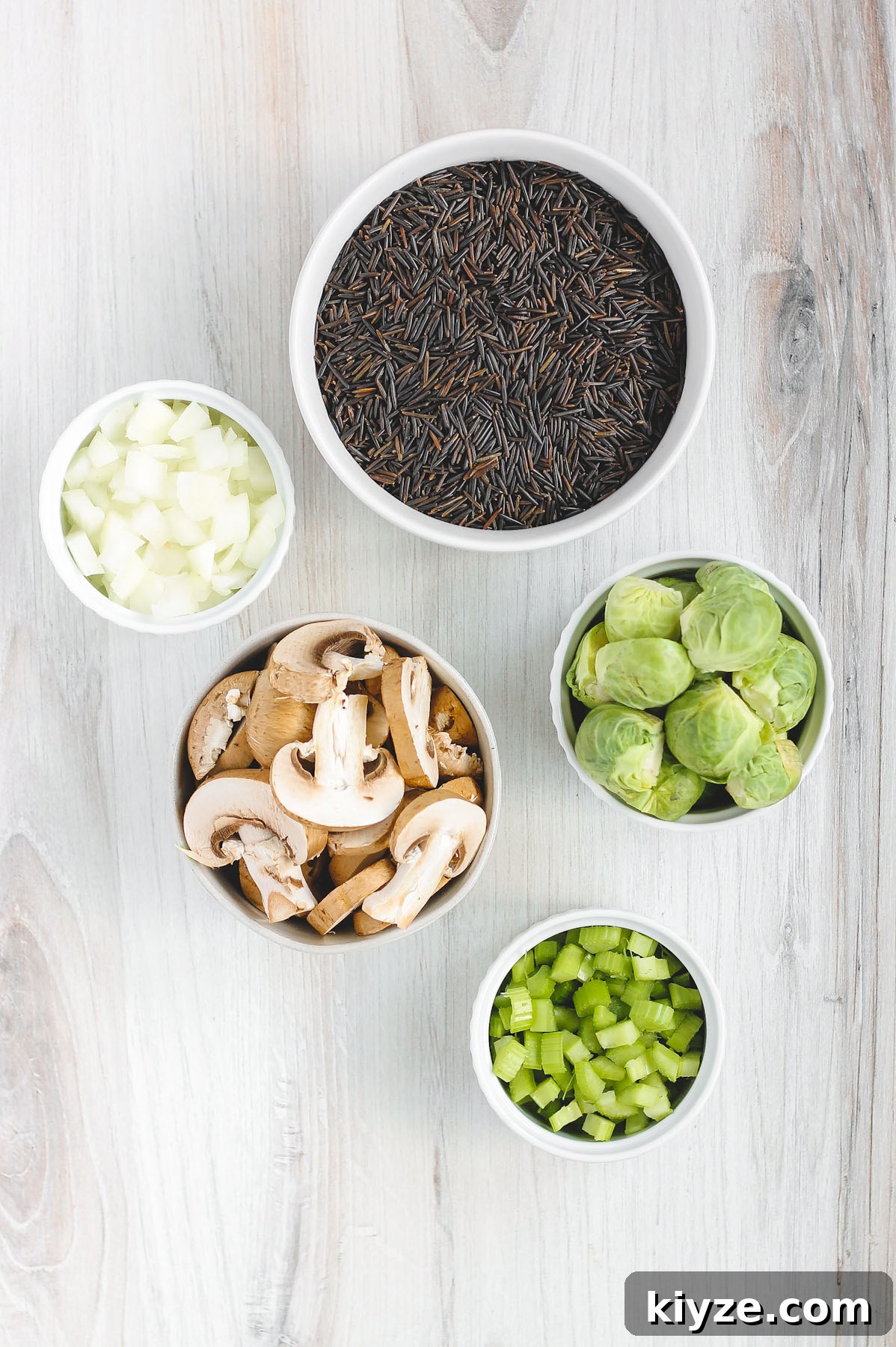 Slow Cooker Wild Rice Pilaf Recipe for Perfectly Fluffy Rice 4 bowls filled with wild rice, Brussels sprouts, onion, mushrooms and celery that are used in this recipe