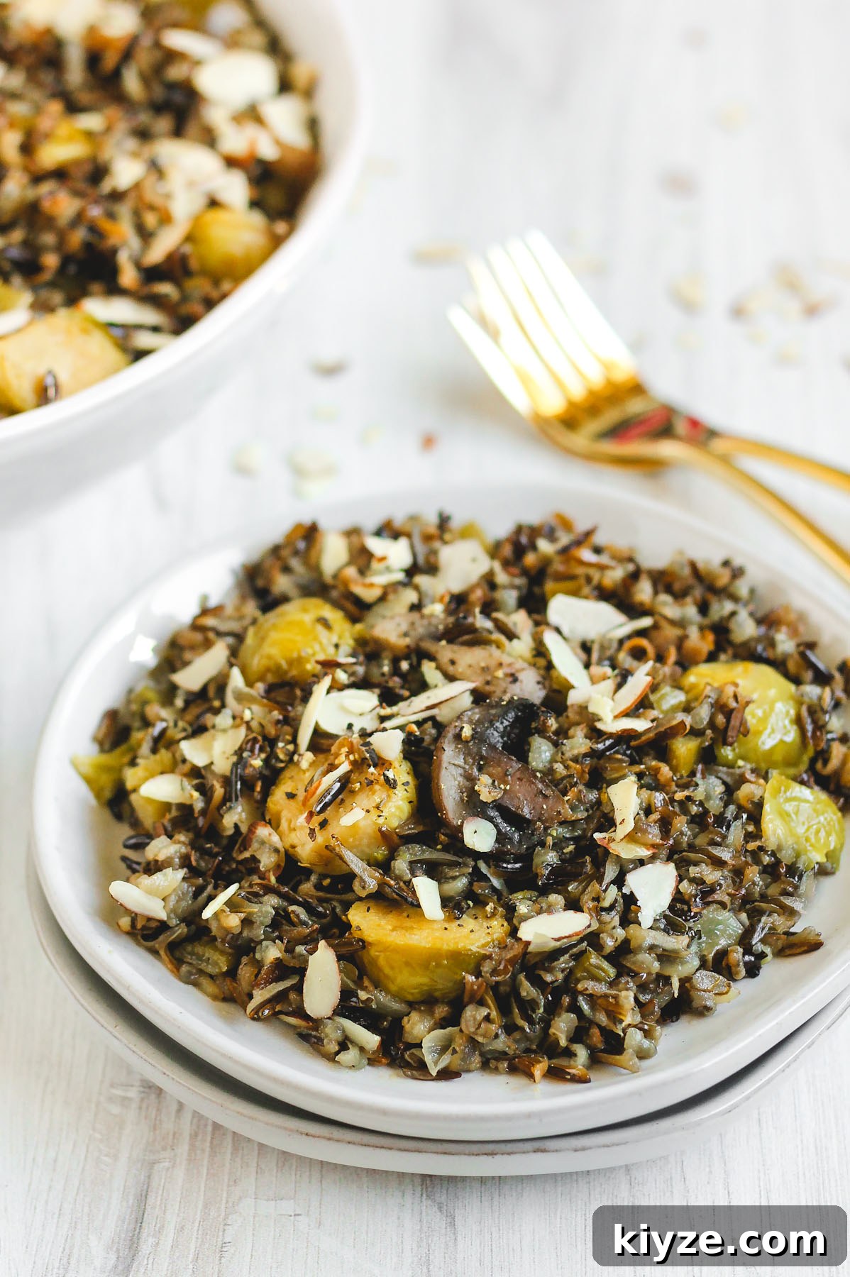Slow Cooker Wild Rice Pilaf Recipe for Perfectly Fluffy Rice 6 wild rice pilaf on a small salad plate with two gold forks behind the plate