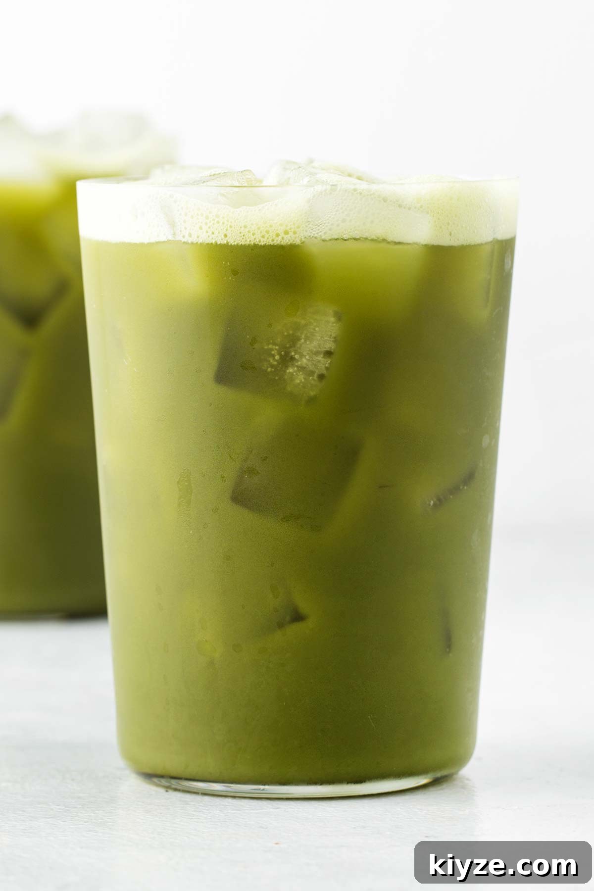 Iced Pineapple Matcha Latte Recipe: Refreshing Tropical Drink 9 A glass of iced pineapple matcha with a second one in the background.