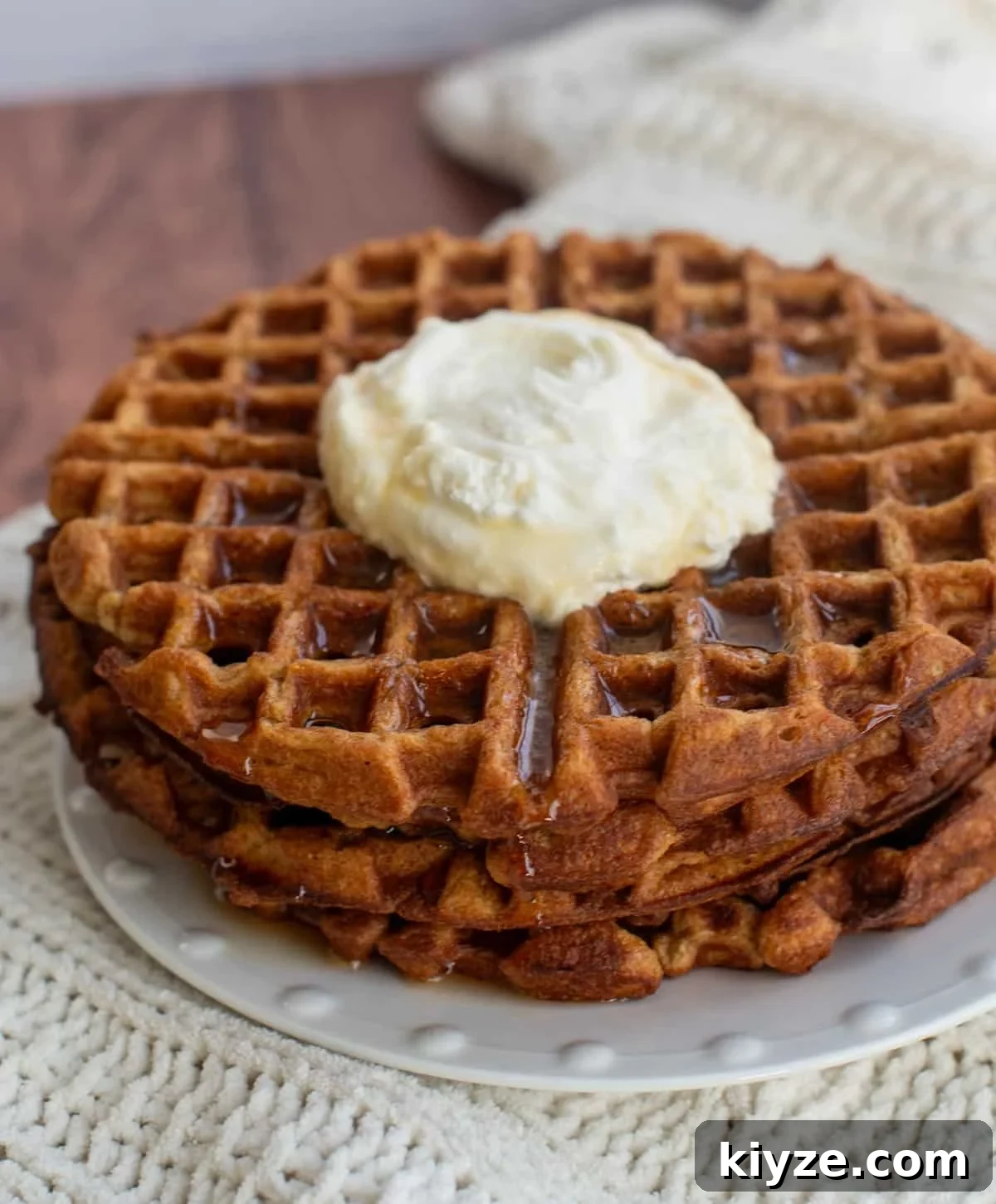 Sourdough Gingerbread Waffles Recipe — Crisp Spiced Morning Treat 2 A stack of Sourdough Gingerbread Waffles on a plate with whipped cream in the middle.