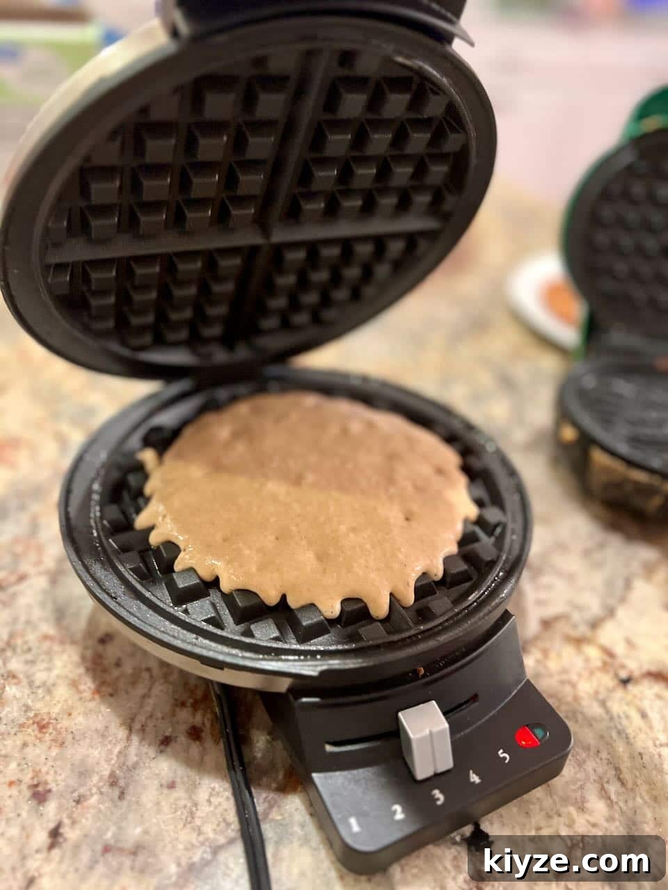 Sourdough Gingerbread Waffles Recipe — Crisp Spiced Morning Treat 6 Batter on top of an open waffle iron.