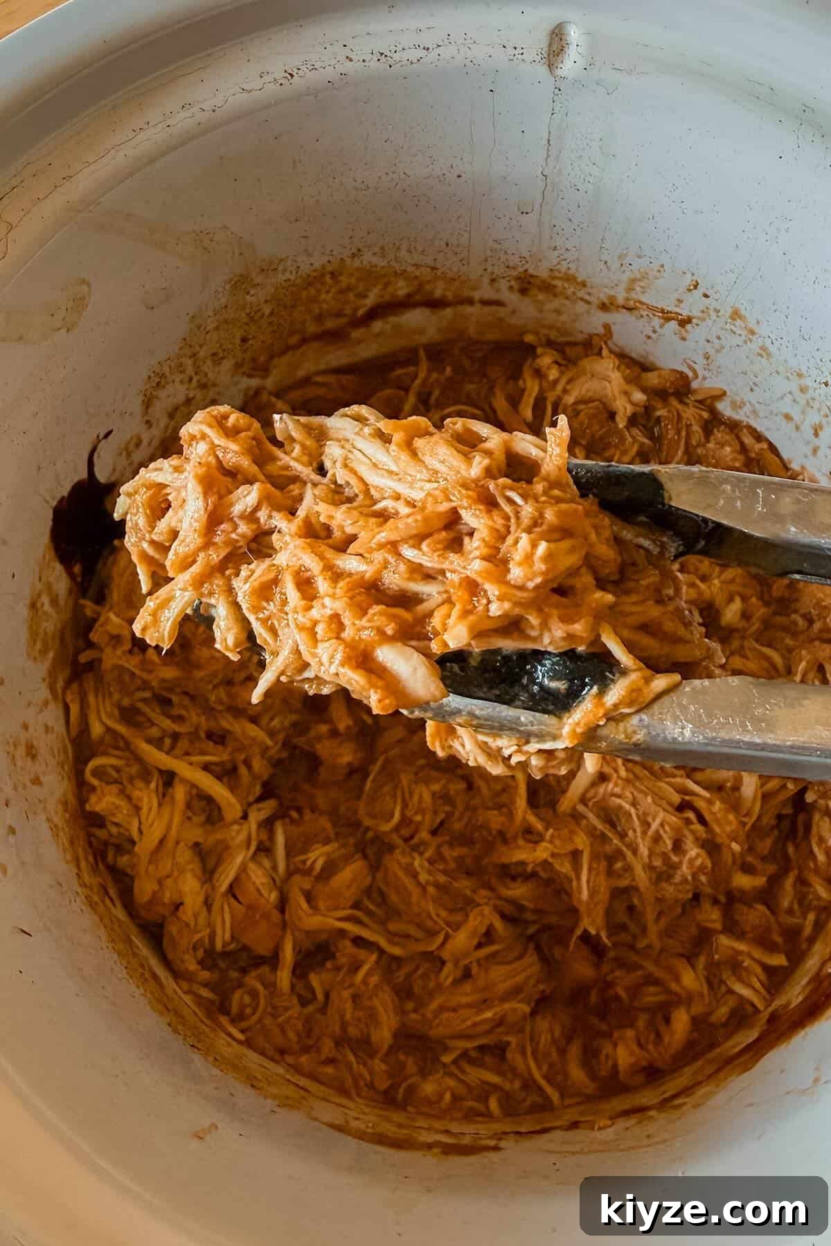 Graduation Party Menu Ideas: 6 Crowd-Pleasing Meal Plans 6 A close up of bbq shredded chicken held by tongs.