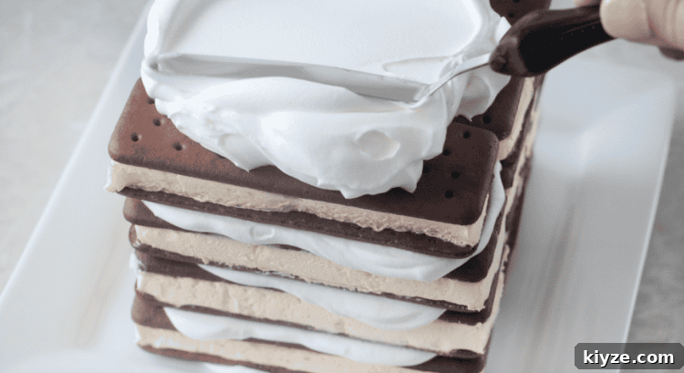 How to Make an Ice Cream Sandwich Cake (Video Tutorial) 7 stack of ice cream sandwiches frosted with whipped cream