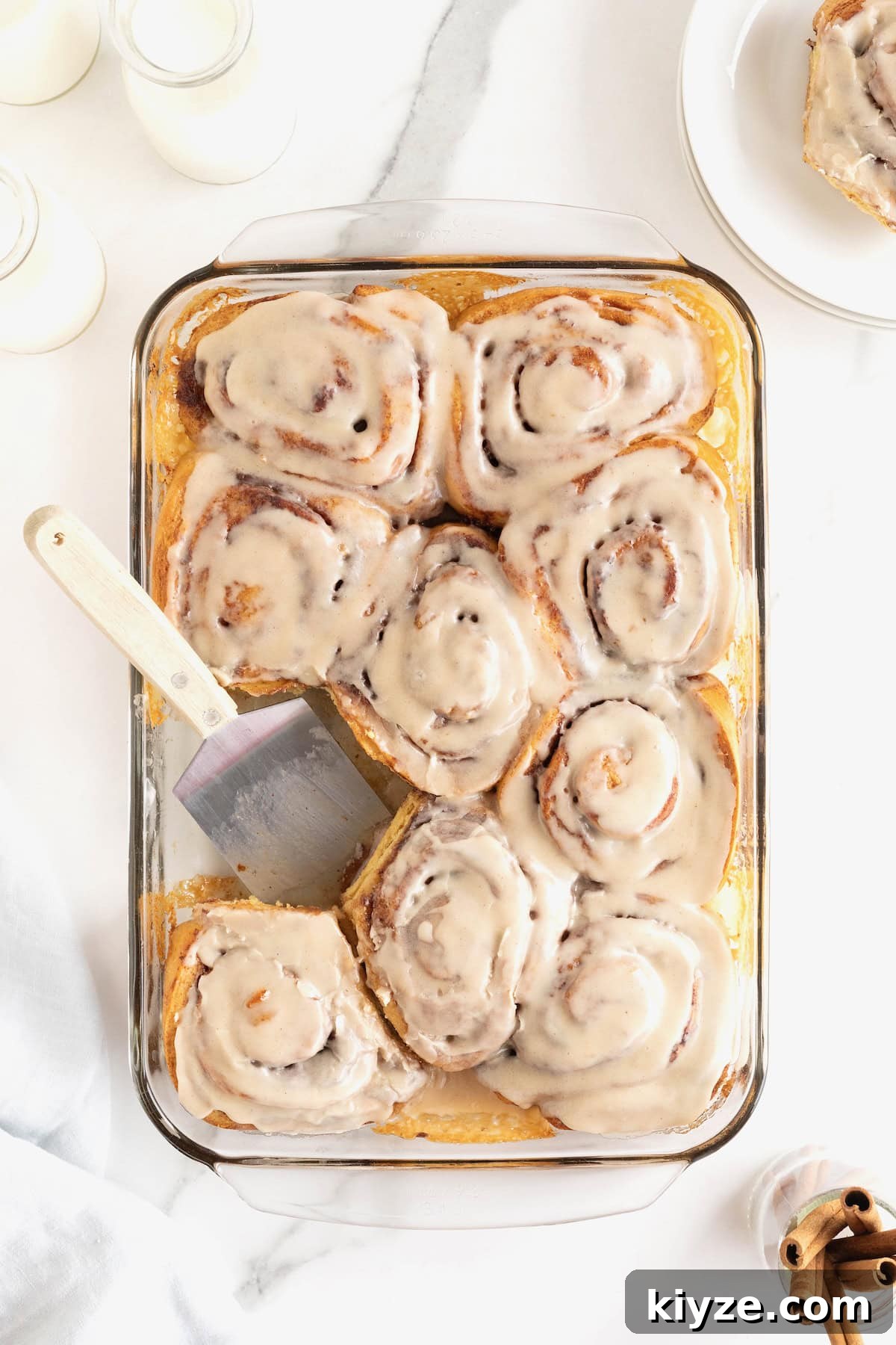 Quick Canned Cinnamon Rolls: Fast Oven & Air Fryer Hack 11 Store bought cinnamon rolls in a glass baking dish topped with icing.