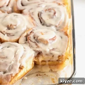 Store bought cinnamon rolls in a glass baking dish topped with icing.
