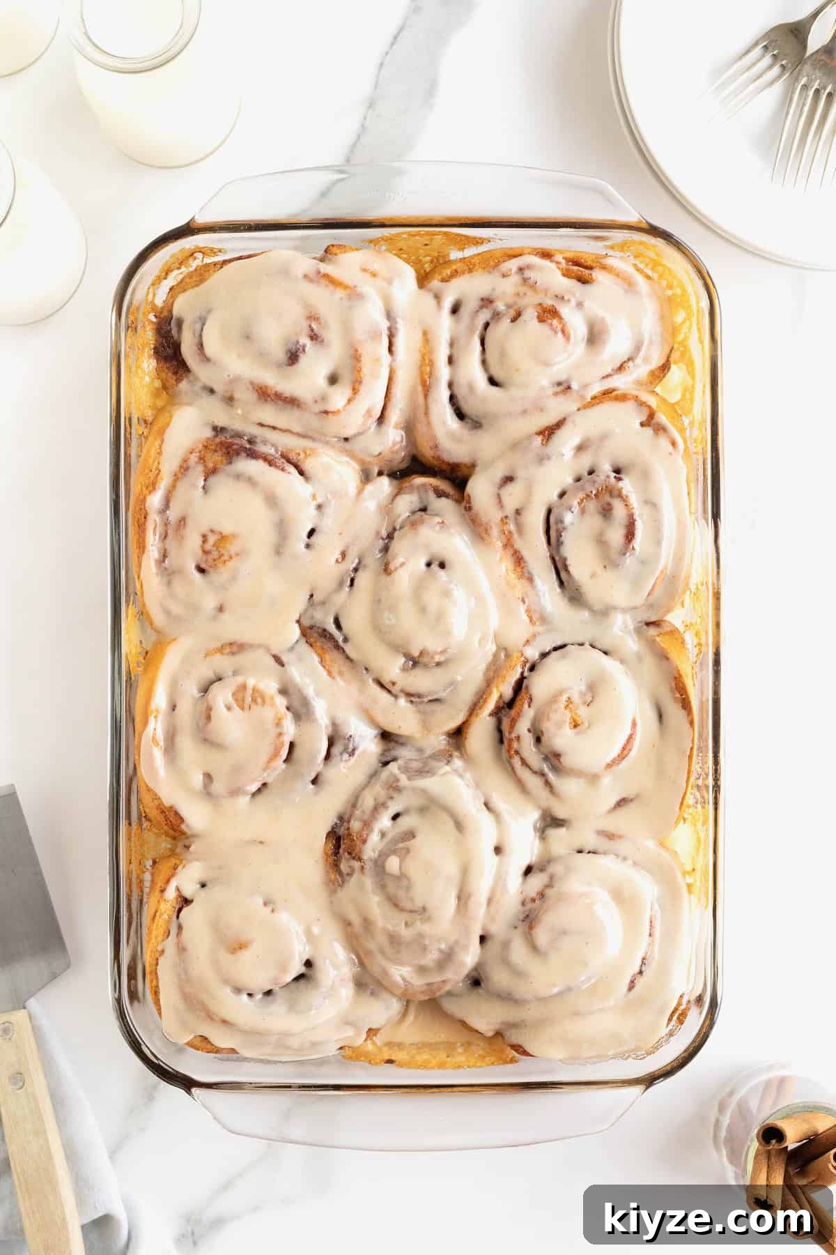 Quick Canned Cinnamon Rolls: Fast Oven & Air Fryer Hack 10 Store bought cinnamon rolls in a glass baking dish topped with icing.
