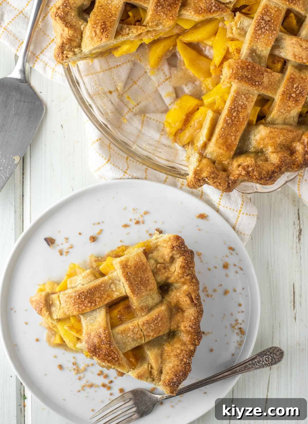 Peach and Mango Pie Recipe: Flaky Crust with Luscious Filling 3 overhead shot of slice of peach mango pie on white plate with more in pie plate