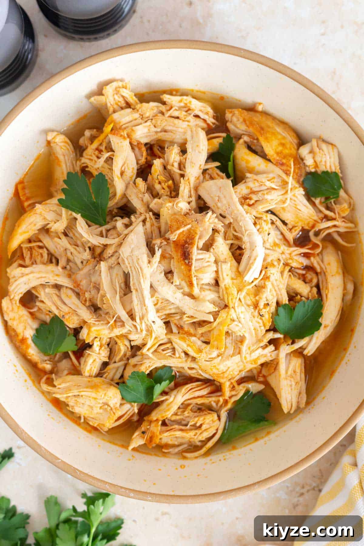 Shredded Chicken Made in a Dutch Oven: Tender Slow-Cooked Recipe 2 Overhead view of a bowl of Dutch oven shredded chicken with cilantro.