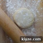An all butter dough on a work surface with a rolling pin.