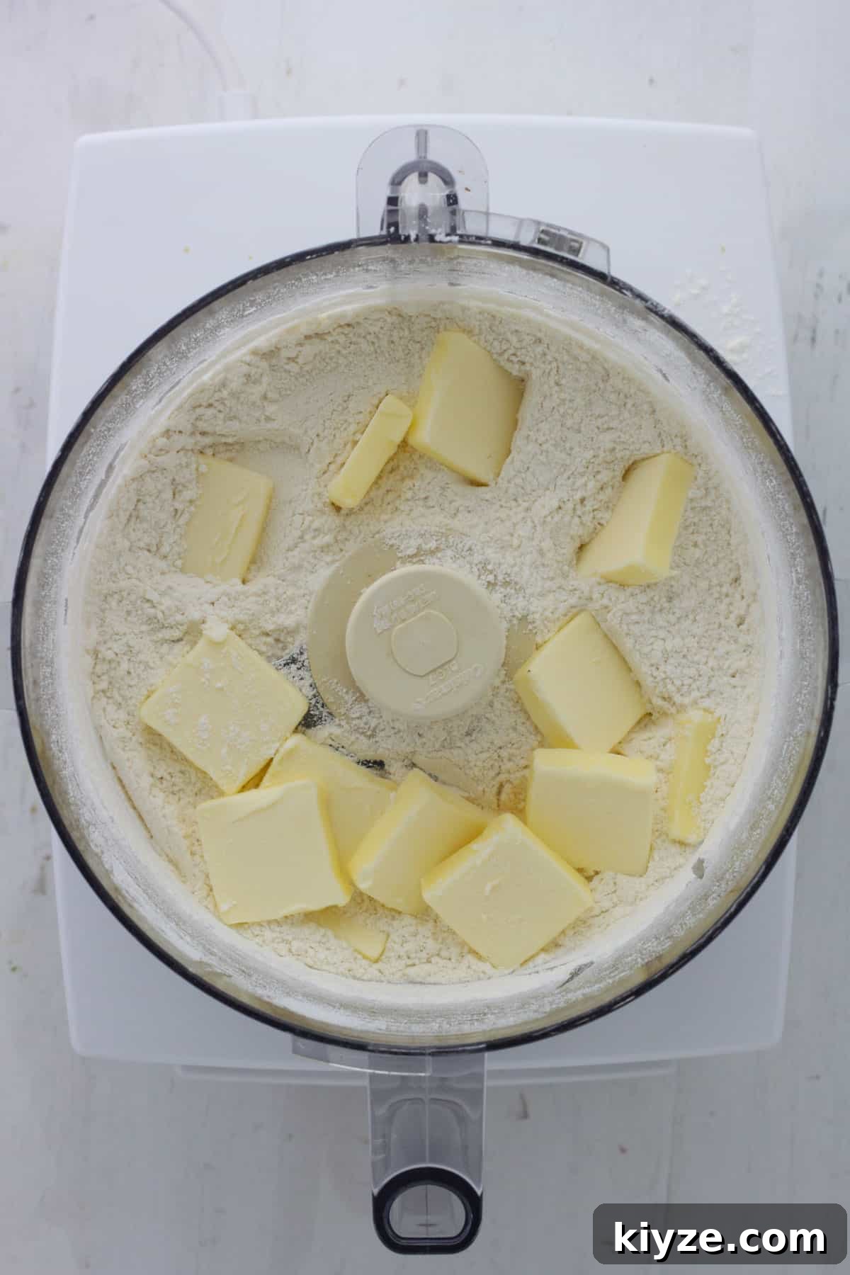 Butter Pie Crust Made in a Food Processor: Quick Recipe 4 Flour, salt and sugar in the base of a food processor with pads of butter on top.