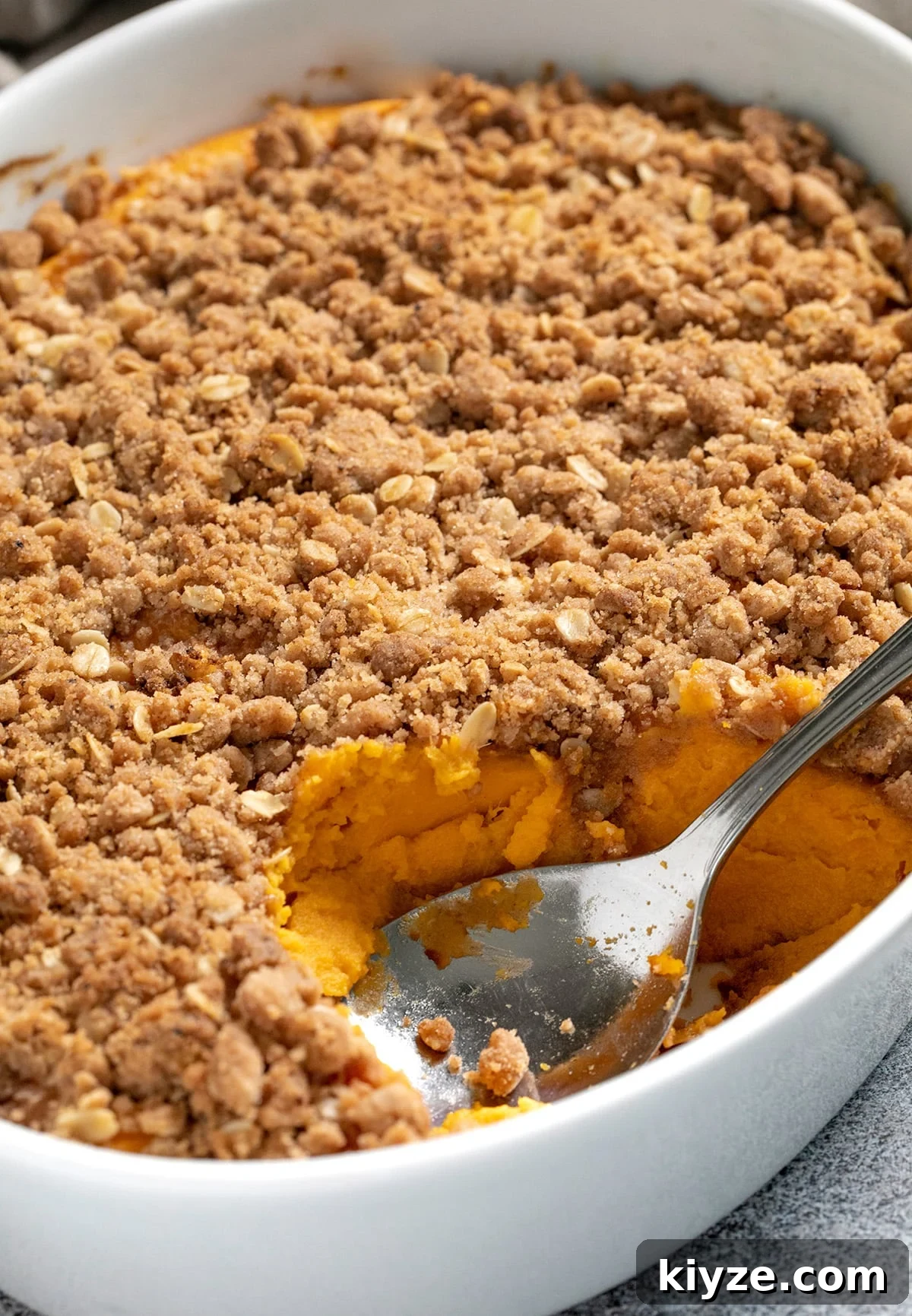 Gluten-Free Sweet Potato Casserole Recipe for Holidays 2 Sweet potato casserole dish with serving spoon closeup image