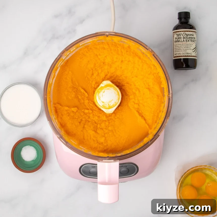 Gluten-Free Sweet Potato Casserole Recipe for Holidays 14 A food processor containing smooth pureed orange sweet potatoes surrounded by the same small bowls of other ingredients.