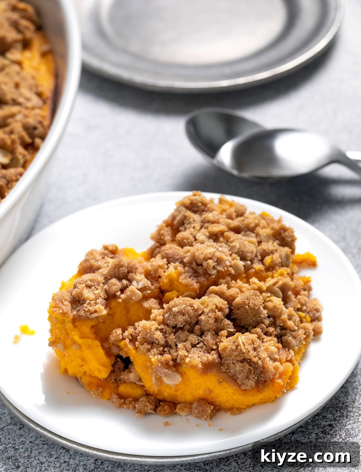 Gluten-Free Sweet Potato Casserole Recipe for Holidays 6 Sweet potato casserole serving on small white plate with spoons and serving dish