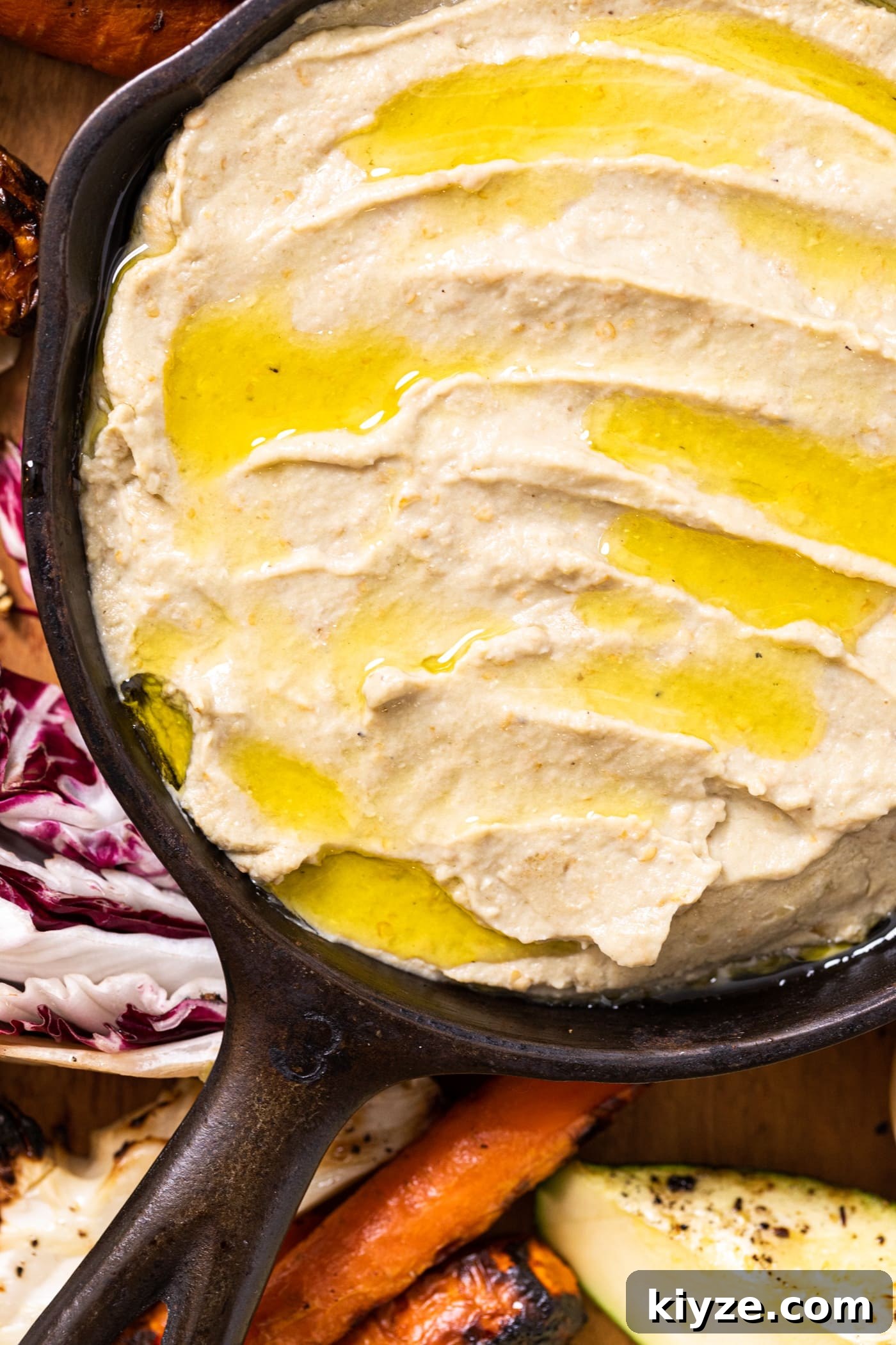 Authentic Baba Ganoush Recipe: Smoky Eggplant Dip Guide 4 Close up top down view of Baba ganoush in black cast iron skillet with olive oil all over the top with grilled vegetables around