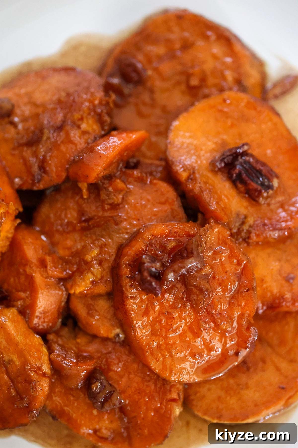 Bourbon-Glazed Candied Yams Recipe for Holiday Sides 2 bourbon candied yams with pecans on top.