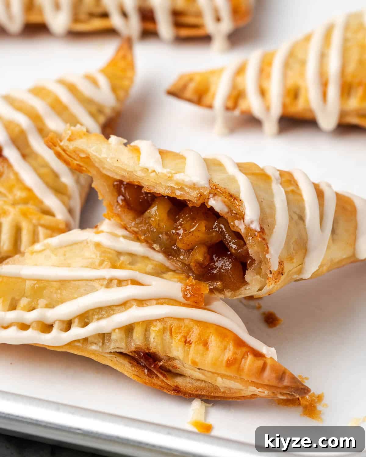 Flaky Apple Turnovers with Puff Pastry Recipe 2 An apple turnover cut in half showing the flaky pastry layers and spiced apple filling.