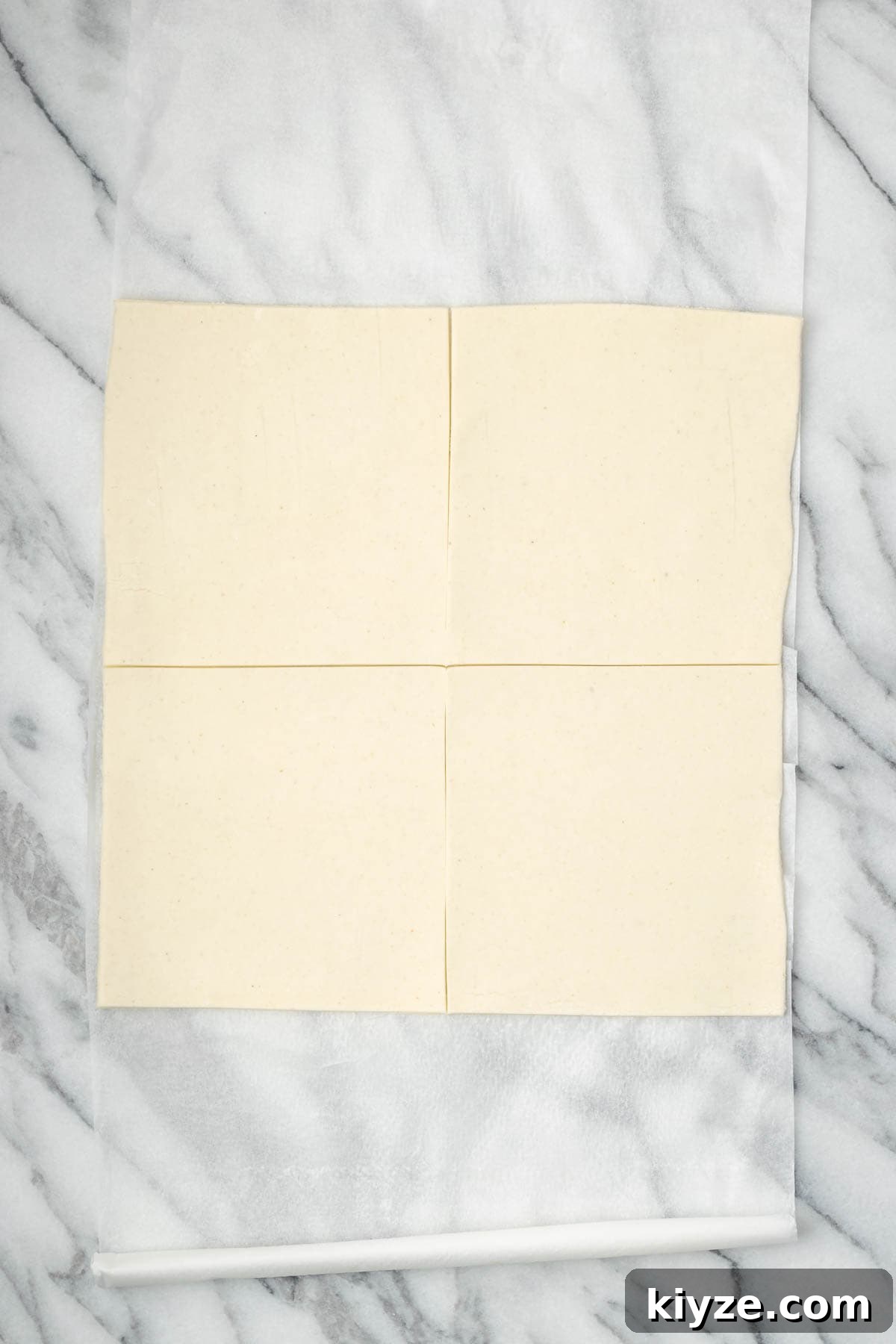 Flaky Apple Turnovers with Puff Pastry Recipe 6 A sheet of puff pastry cut into four squares.
