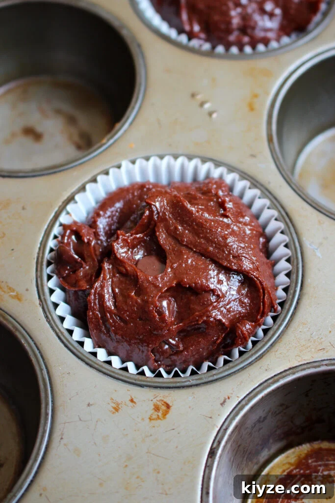 Fudgy Brownie Muffins Recipe: Chocolate Muffins with Gooey Centers 14 Scooping into liners