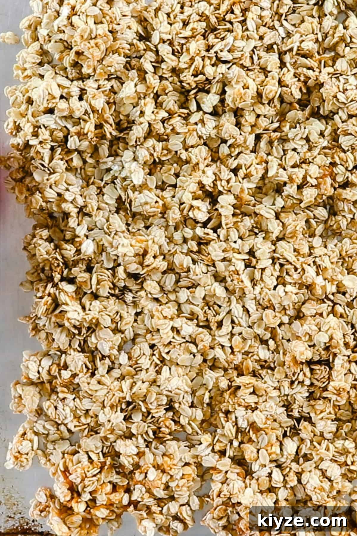 Pumpkin Spice Granola Recipe Made from Scratch 5 Spreading pumpkin granola on a sheet pan to bake.