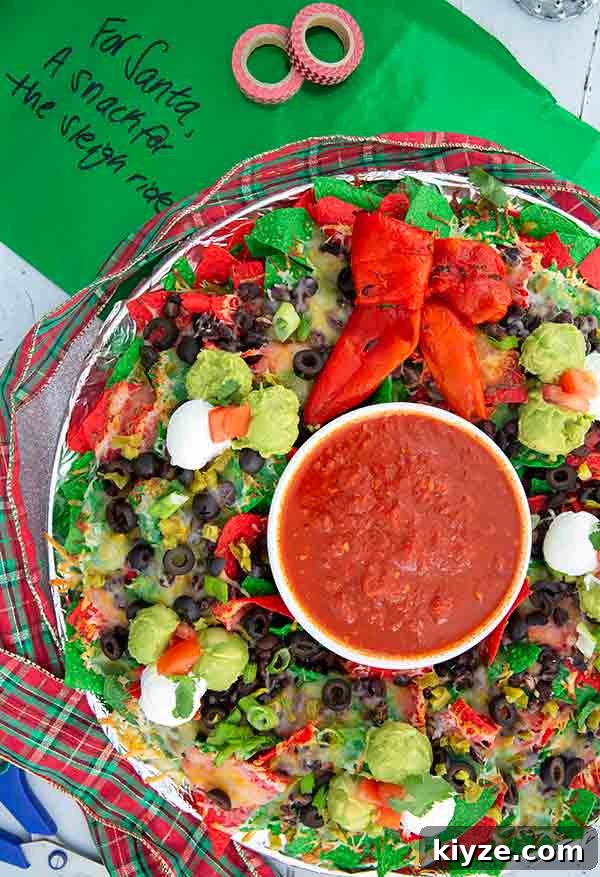 Festive Christmas Wreath Nachos Recipe: Holiday Appetizer Idea 2 Nachos in the shape of a Christmas wreath with green tissue paper in the background