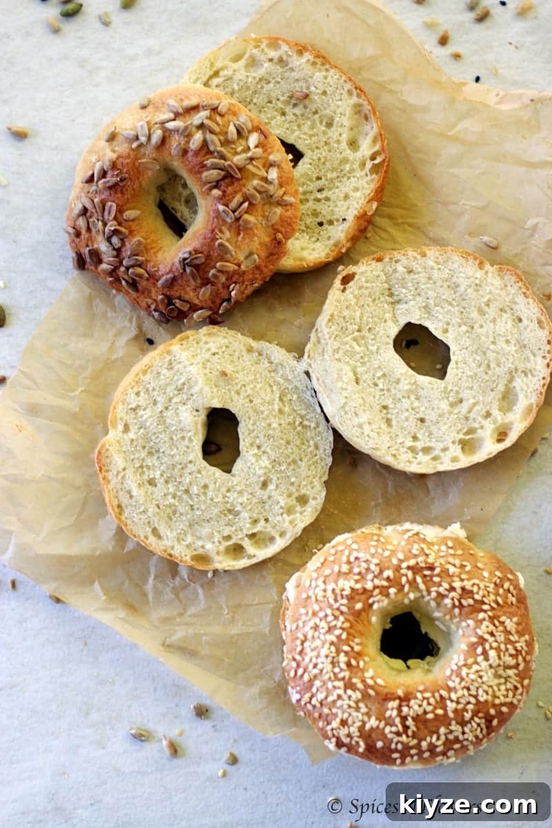 Homemade Bagels: A 5-Step Recipe for Perfect Chewy Bagels 11 bagels sliced horizontally to show the texture from within is placed on a parchment paper