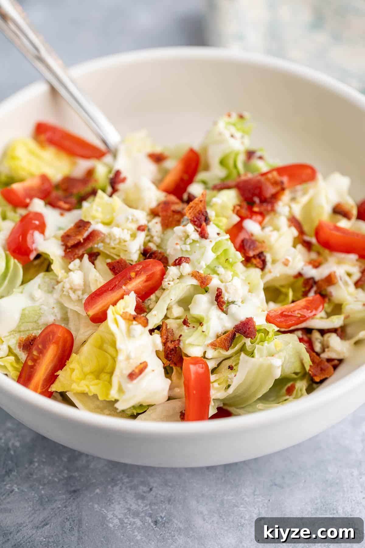 Classic Blue Cheese Wedge Salad with Crispy Bacon and Dressing 6 A chopped wedge salad in a bowl.